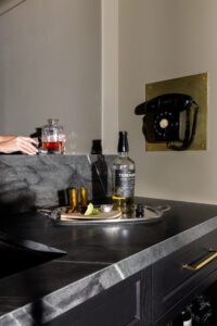 bar set up in speakeasy with alcohol bottles and limes
