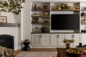 cream TV built ins with vintage decorations and greenery